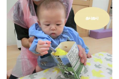 バナナを絵の具の入った容器の中に<br>何度も出し入れし、<br><span style='color:#ff2391;'>た～っぷり</span>と<br><span style='color:#ff8914;'>チョコレート</span>をつけること<br>ができた子ども達<span style='font-size:1.2em;'><span style='color:#ff2391;'>♥</span></span><br><br>その後は仕上げに<br>上から<span style='color:#0a84ff;'>キラキラパウダー</span>をトッピングします<span style='font-size:1.2em;'><span style='color:#ff0f87;'>★</span></span>