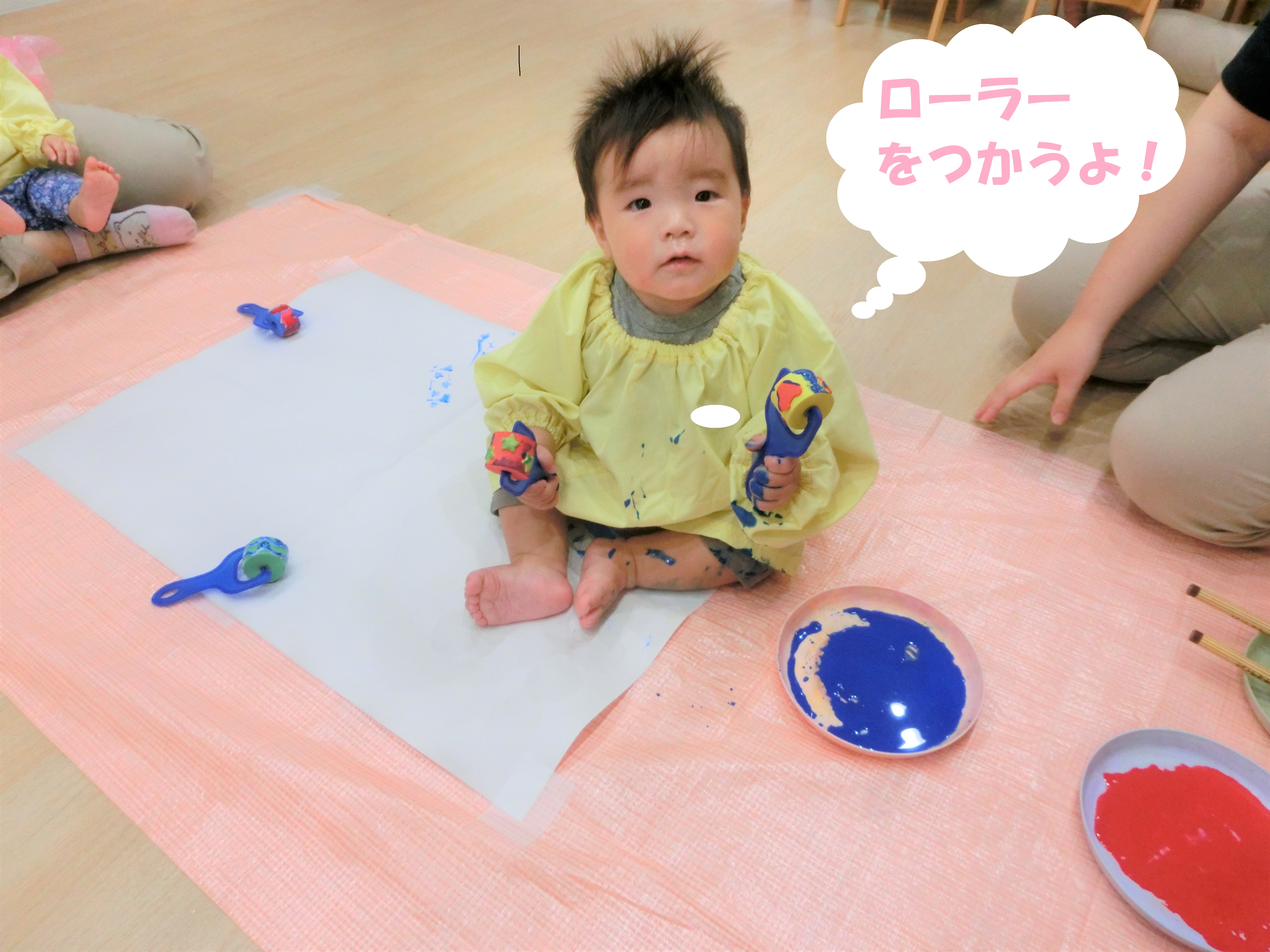 大きな<span style='color:#70b7ff;'>模造紙</span>と、<span style='color:#6bb5ff;'>ローラー</span>を用意して<br>絵の具遊びをしました<span style='color:#75ffff;'>(^^♪</span><br><br>「<span style='color:#b5ff6b;'>なんだろう?</span>」と興味を持って<br>ローラーを手にする子どもたち、<br>初めは先生と一緒に握って<br><span style='color:#ff70ff;'>色を付けて</span>楽しみました<span style='color:#ffb770;'>(^^♪</span><br><br>慣れてくると、<br>自分で<span style='color:#ff70b7;'>色を付けて</span>紙に<span style='color:#ff70b7;'>ころころ♪</span>
