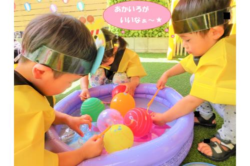 その後ろでは<span style='color:#ff00ff;'>うさぎチーム</span>(2歳児)が<br><span style='color:#75baff;'>ヨーヨー釣り</span>に挑戦<span style='color:#ff0000;'>!!</span><br><br><span style='color:#ff7f00;'>ひよこチーム・りすチーム</span>(0,1歳児)は<br><span style='color:#00ff00;'>虫取り網</span>を使い、<br><span style='color:#ff00ff;'>うさぎチーム</span>は少し難しい<br><span style='color:#007fff;'>ヨーヨー釣り竿</span>を使いました<span style='color:#ffff00;'>★</span><br>輪の中に先っぽを通そうと頑張っていましたが<br>難しくて<span style='color:#ba75ff;'>手</span>も使っていました<span style='color:#ff3d3d;'>!</span><br><br><span style='color:#7abcff;'>先生</span>は<span style='color:#ff7aff;'>見なかったことに</span>…(笑)<br>