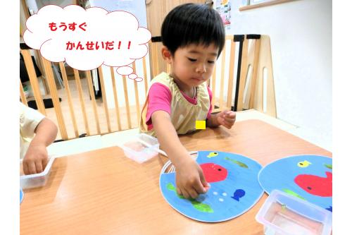 <span style='color:#ff0000;'>お魚</span>の色が乾いたら<span style='color:#bc7aff;'>丸い<br>シール</span>を貼って完成<span style='color:#ff7f00;'>!!</span><br><br><span style='color:#ffba75;'>パタパタ</span>とあおいで<br>「きもち~」「せんせいにもしてあげる!」<br>と<span style='color:#7abcff;'>心地よい風</span>をおくってくれました(<span style='color:#ff00ff;'>*</span>^^<span style='color:#ff00ff;'>*</span>)<br>