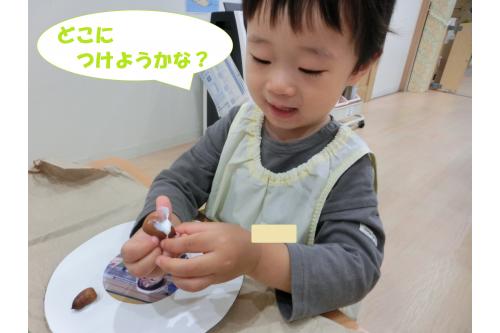 <span style='color:#00ff00;'>うさぎチーム（2歳児）</span>は<br>公園で拾ってきた<span style='color:#7f00ff;'>どんぐり</span>や<br><span style='color:#00ff7f;'>葉っぱ</span>、先生が見つけてきた<br><span style='color:#ff7f00;'>松ぼっくり</span>を使って…<br>