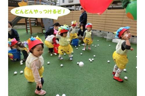 <span style='color:#ff7f00;'>鬼のパンツ</span>と<span style='color:#7f00ff;'>鬼帽子</span>を着て<br>早速園庭へ!<br><br><span style='color:#00ff00;'>風船鬼</span>めがけてボールをえいっ!<br>
