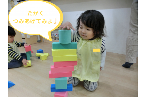 お友達が<span style='color:#75baff;'>ブロック</span>を<span style='color:#75ffba;'<br><br>高く積み上げて</span>遊んでいると<br>その様子を見ていた他のお友達も<br>「<span style='color:#ff1e8e;'>これやりたい</span>」と<br>言って一緒に<span style='color:#ff0fff;'>挑戦</span><span style='color:#ffb266;'>♪</span>