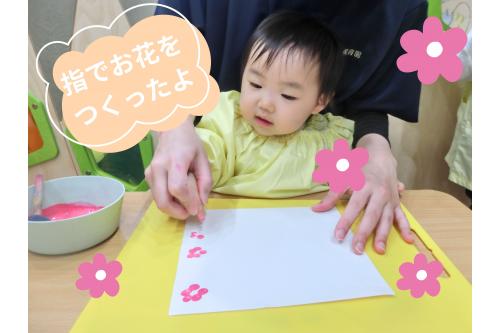 次は、<span style='color:#ff60af;'>お花をつくりました</span>♪<br><br>先生と一緒に<span style='color:#ff4c4c;'>指スタンプ</span>！<br>絵の具が手に着くのが苦手な子は<br><span style='color:#4ca5ff;'>スポンジスタンプ</span>に挑戦しました！<br>