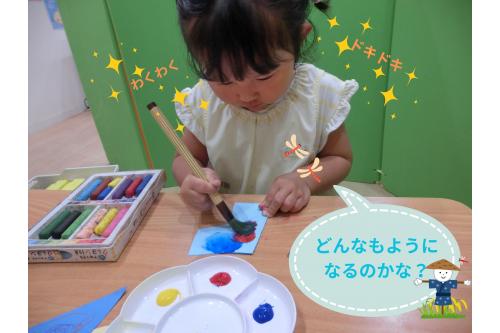 <span style='color:#70ff70;'>かかしの服</span>を<span style='color:#7575ff;'>デカルコマニー</span>で<br>模様を付けました！<br><br><span style='color:#b7ff70;'>自由に筆で色を付ける</span>子どもたち、<br>画用紙を半分に折りたたんで<br>アイロンをすると…<br><br><span style='color:#b770ff;'>どんな模様になるんだろう？</span>