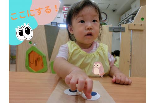 今回作ったのは紙袋で「フクロウ」<br><br>まずは<span style='color:#ff007f;'>目</span>を貼ります！<br><br><span style='color:#7f00ff;'>この辺りね</span>と伝えると<br><span style='color:#00ff00;'>場所を確認しながら</span>貼り進めた子どもたち。<br>